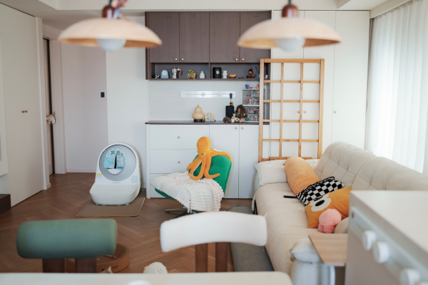 Sala de apartamento com sofá, móveis e caixa de areia para gato